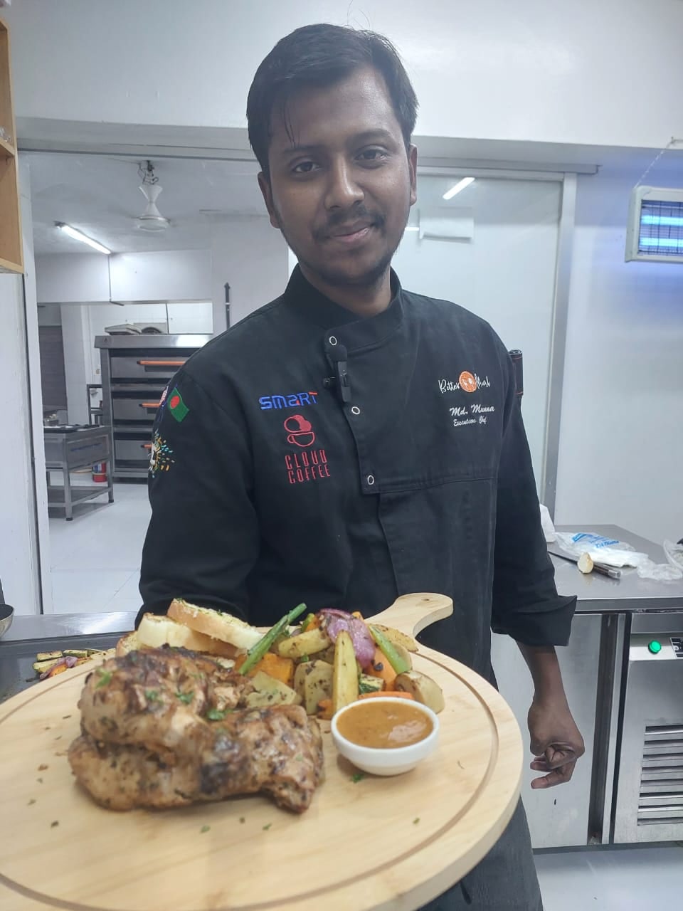 Chef Munna presenting a plated dish in a kitchen setting