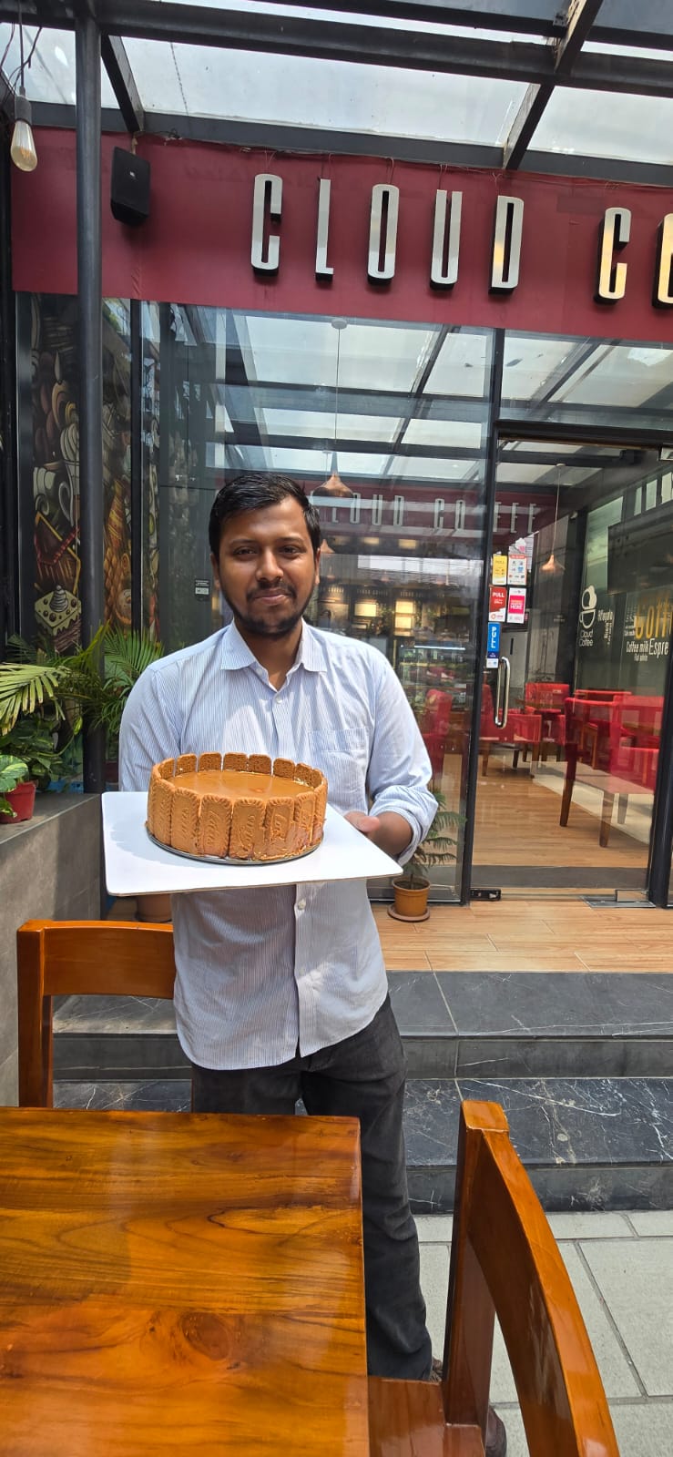 Chef Munna holding a finished cake outside Cloud Coffee