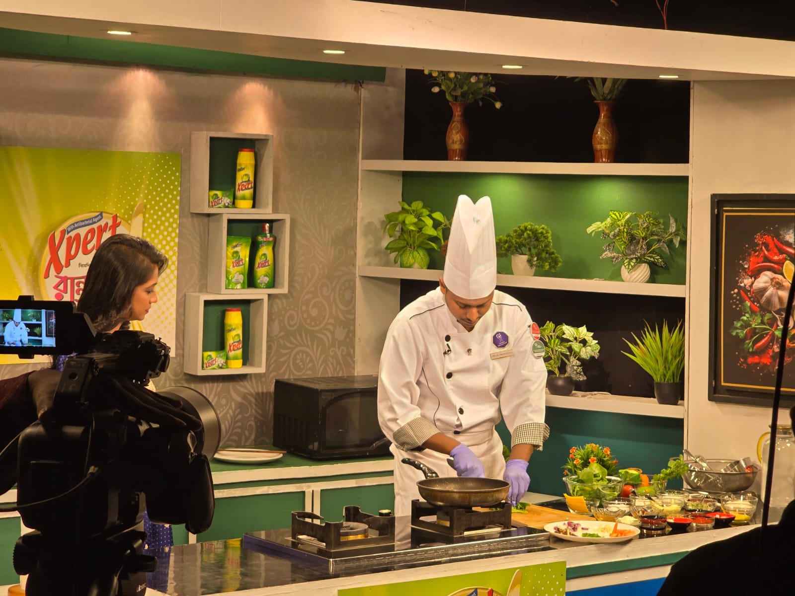 Chef Munna cooking on a television studio set with cameras visible around the workstation