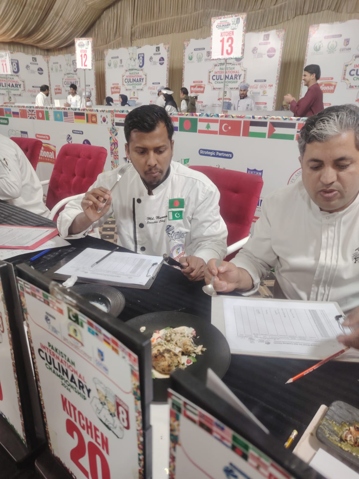 Chef Munna evaluating a plated competition dish at a judging station